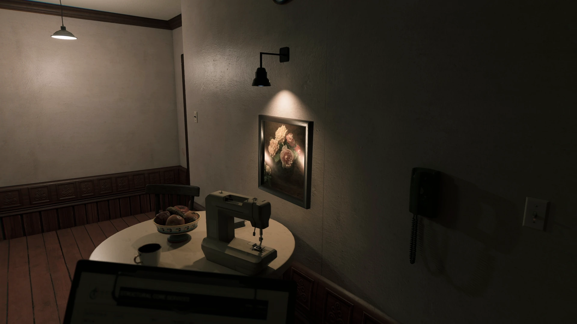 A sconce lighting a flower painting above a round table with a sewing machine in Unit 47, PROPERTY INSPECTION.